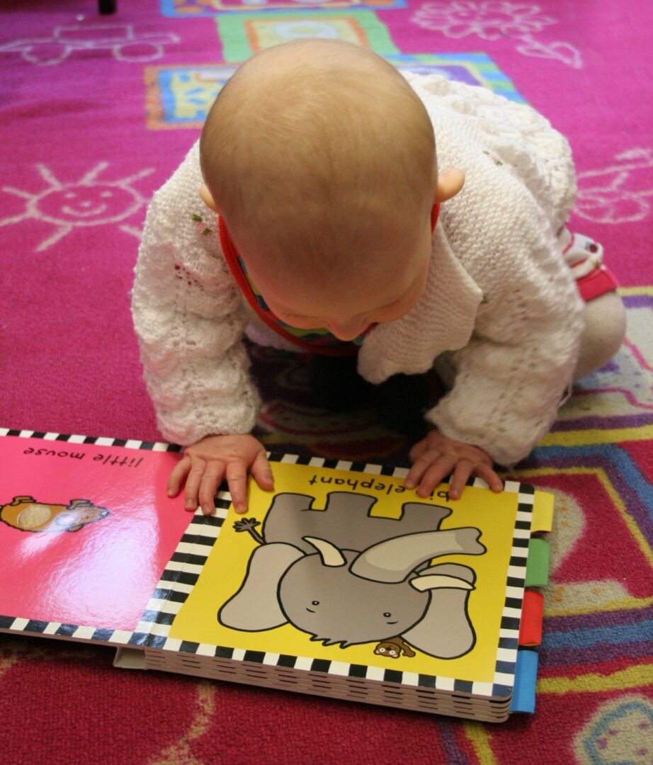 un bambino che gioca con i libri sul pavimento