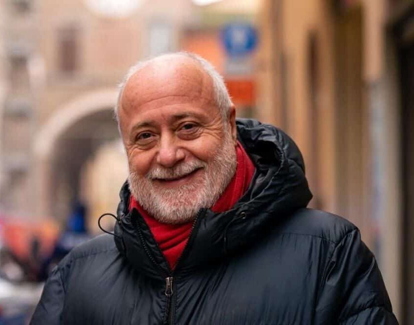 un uomo con una giacca nera e una sciarpa rossa