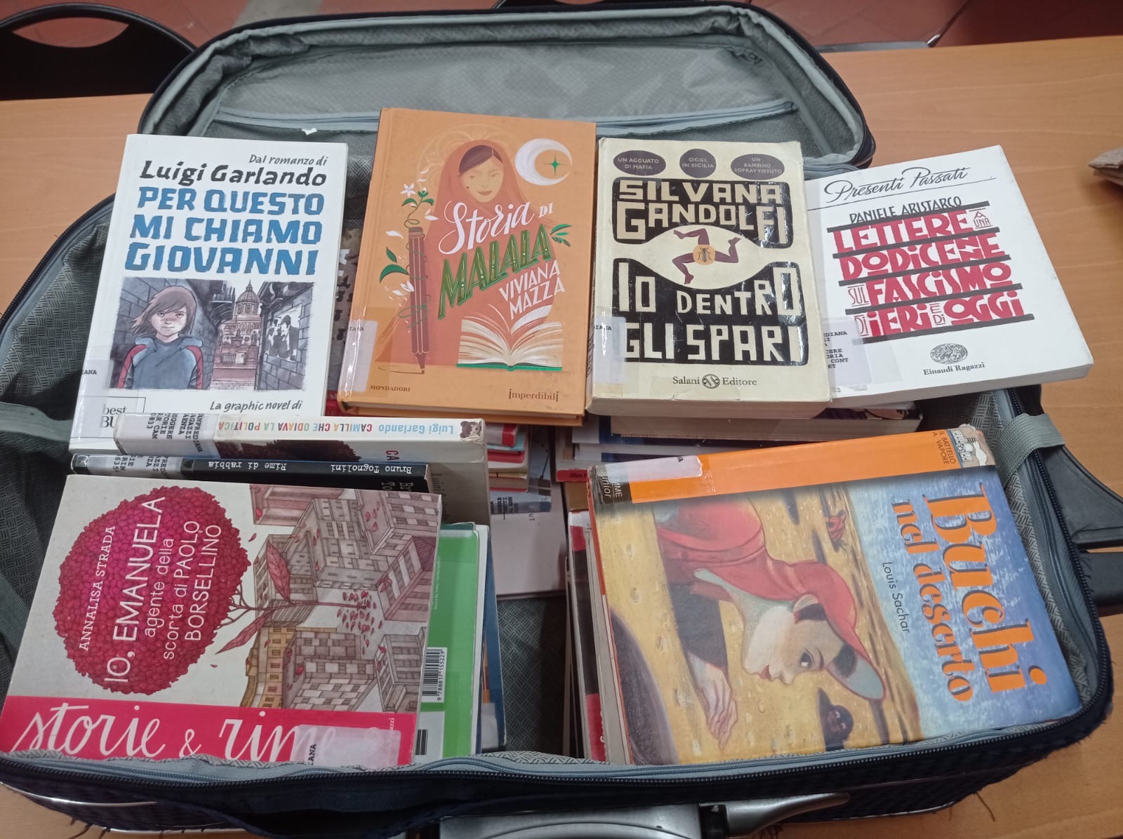 a suitcase filled with lots of books on top of a table